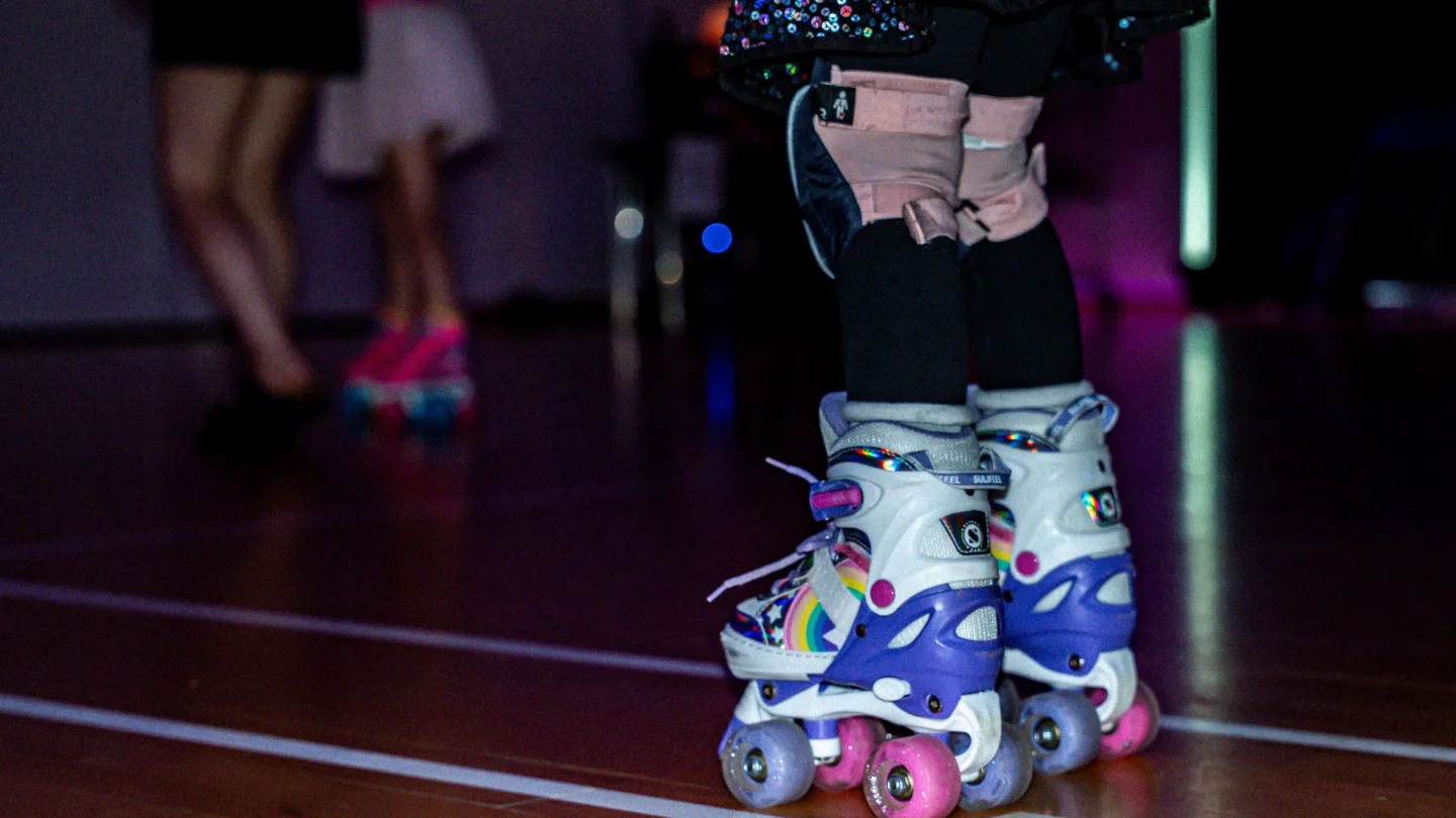 A photo of a child's feet in purple and white roller skates