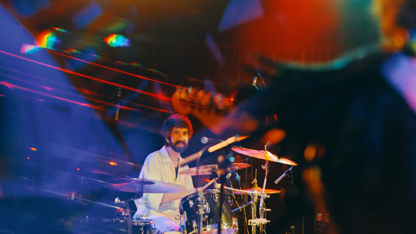 A blurry photo of a man playing the drums