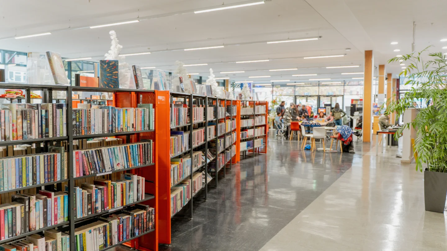 A photo of orange bookshelves in the library of Deptford Lounge.