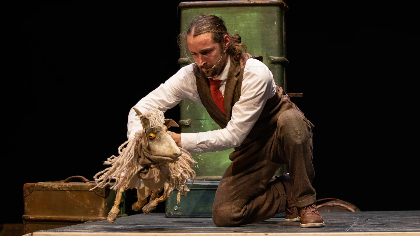 A person moving a puppet goat