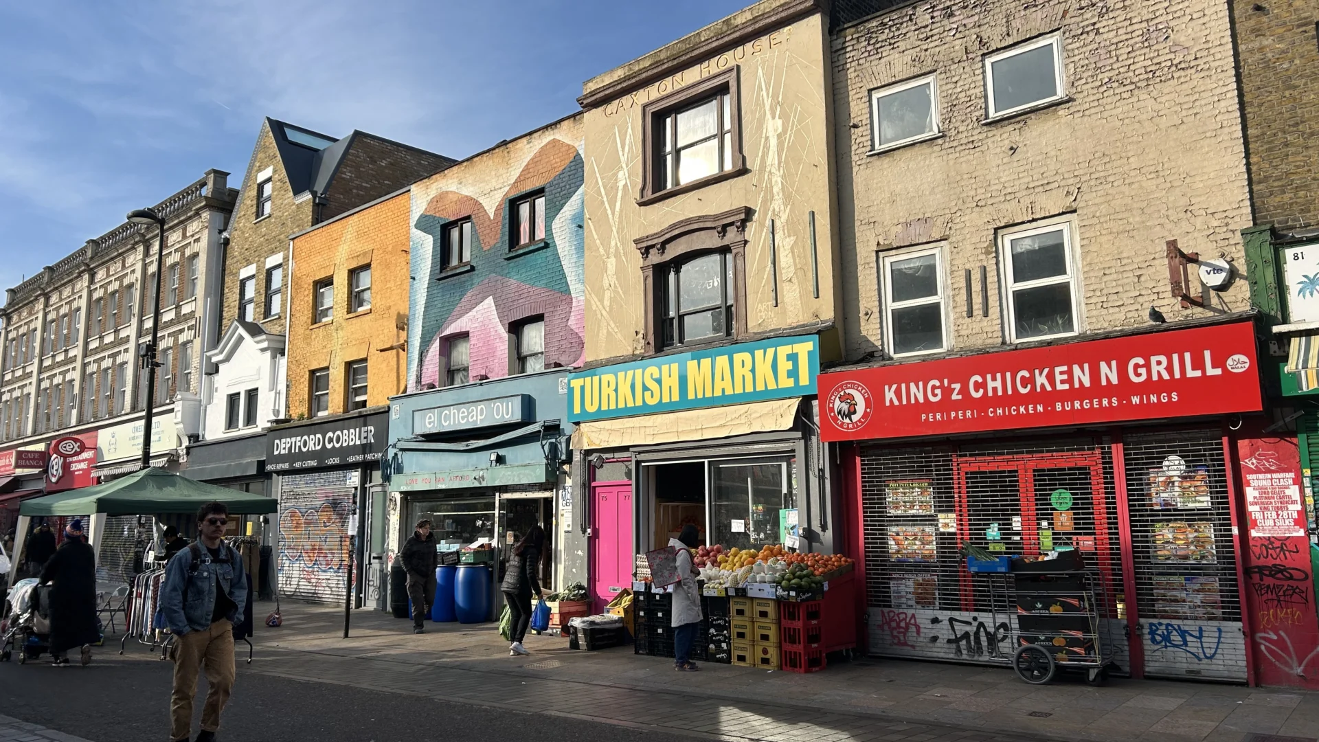 A photo of colourful shops on Deptford High Street on a sunny day.