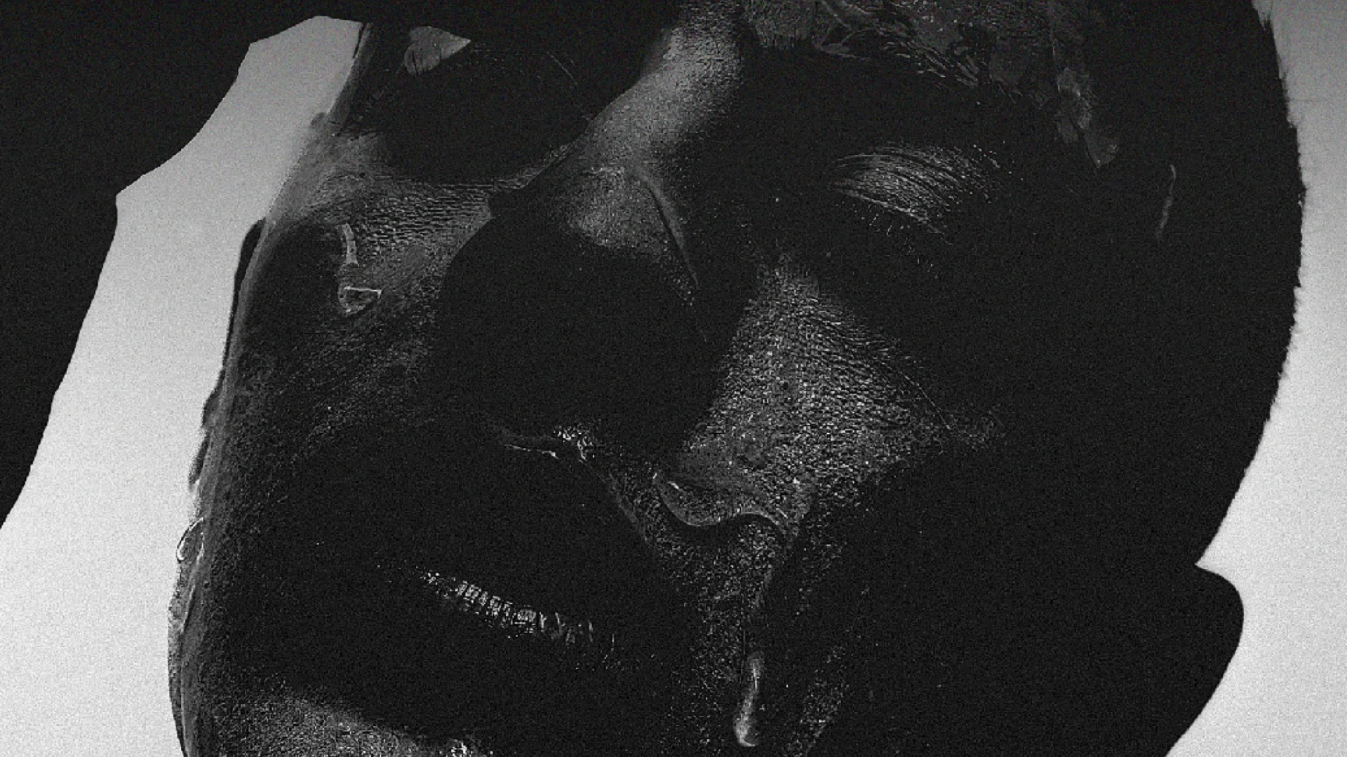 A black and white photograph of a person with their eyes closed.