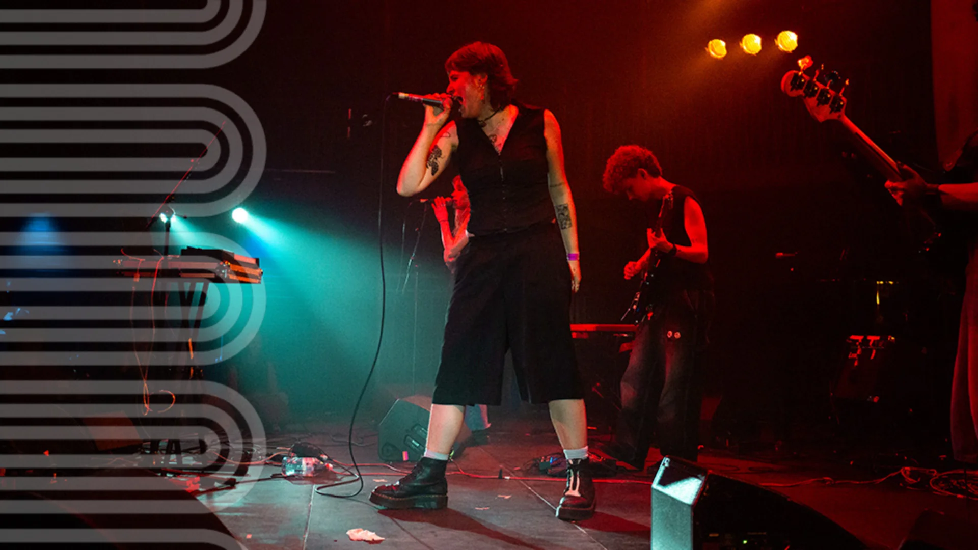 person on stage singing into a microphone