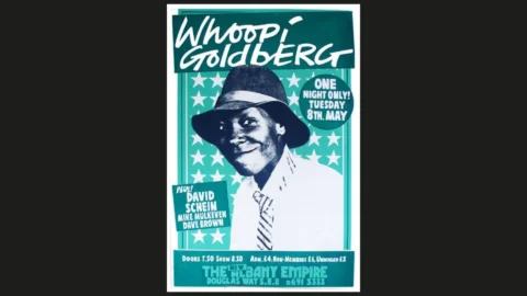 A blue and white poster with a photo of Whoopi Goldberg in a shite, tie and hat.