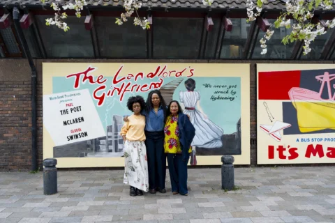 A photo of three women - Mimi Findlay, Vicki Amedume and Michelle Matherson - stood in front of a brightly coloured mural on the side of the Albany building.