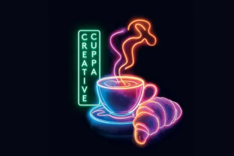An illustration of a neon sign on a black background. The neon sign says 'Creative Cuppa' in vertical writing, and also includes a steaming mug of coffee and a croissant. The neon colours are green, blue and pink.