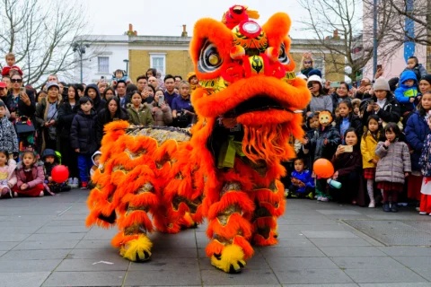 A photo of a giant red and gold dragon surrounded by crowds on Giffin Square.