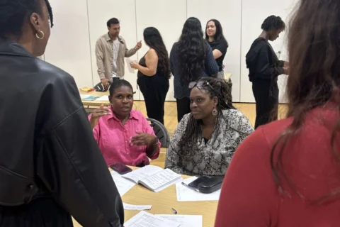 Two people talking to two people behind a table